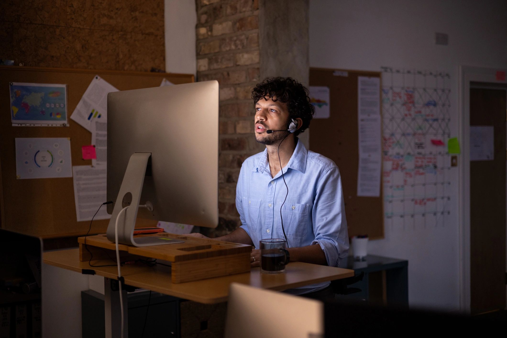 IT support technician working at a standing desk in a modern office